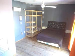 Habitación con cama y estante para libros en Departamentos mora en Santa Teresita