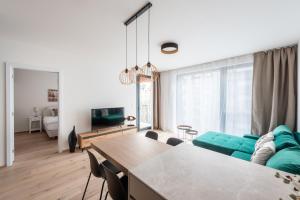 a living room with a green couch and a table at Red Jay Karlin Area Apartment with Garage and Balcony in Prague