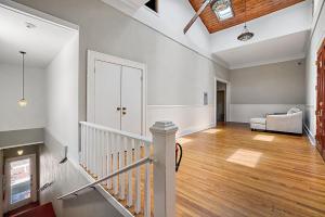 ein leeres Wohnzimmer mit einer Treppe und einer Couch in der Unterkunft Downtown Digs~King Bed~UPSTAIRS Apartment~Downtown Eustis in Eustis