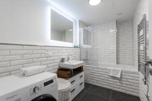 a white bathroom with a washing machine and a sink at Red Jay Karlin Area Apartment with Garage and Balcony in Prague +17 photos