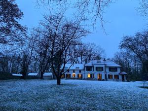una casa bianca con la neve per terra di Manoir au Bois a Kasteelbrakel