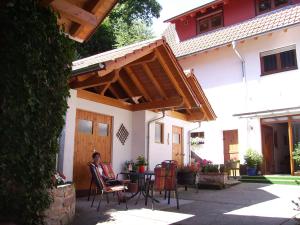 Eine Frau, die an einem Tisch unter einem Schirm sitzt. in der Unterkunft Haus am Kastanienwald in Bad Bergzabern