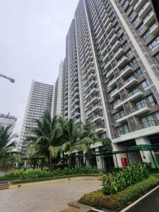 a large apartment building with palm trees in front of it at Mashley Room Prestige Apartment SKY HOUSE BSD in Cilandak