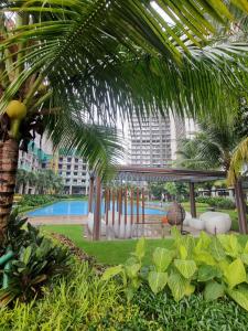 a view of a resort with a pool and palm trees at Mashley Room Prestige Apartment SKY HOUSE BSD in Tjilandak