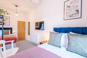 a bedroom with a bed with a blue headboard at Stylish 3Bed Retreat - Walk to Coventry's Delights in Coventry