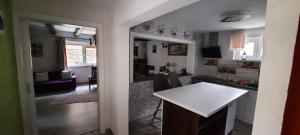 una cucina e un soggiorno con tavolo bianco di Casa Licurici a Govăşdia