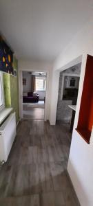 un soggiorno con pavimento in legno massello e una cucina di Casa Licurici a Govăşdia Altre 12 foto