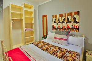 a bedroom with a bed and a painting on the wall at Sweet Mama in Bijilo