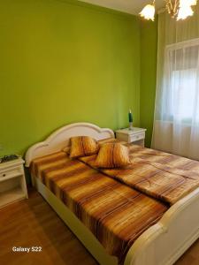 - une chambre avec un grand lit aux murs verts dans l'établissement CASA BOTIMI, à Covasna