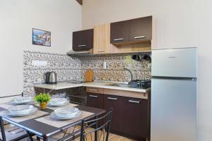 a kitchen with a table with chairs and a refrigerator at Mulberry Apartment in Skala Marion