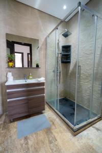 uma casa de banho com um chuveiro e um lavatório. em Moderne appart résidence privée em Tânger