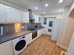 a kitchen with white cabinets and a stove top oven at Private Luxury Rooms RM2 in Northenden