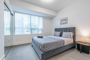 um quarto com uma cama grande e 2 janelas em Luxury Properties in Toronto Downtown Core em Toronto