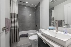 a white bathroom with a sink and a toilet at Luxury Properties in Toronto Downtown Core in Toronto