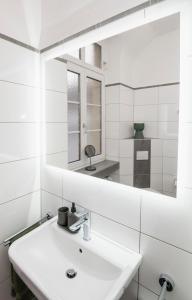 a white bathroom with a sink and a mirror at Center Elegance Light Apartment in Krefeld