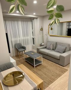 - un salon avec un canapé et une table dans l'établissement Apartamentos Universidad, à Murcie