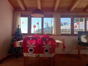 a room with two chairs with reindeer hats on them at Apartment Lärchenheim in Soprabolzano