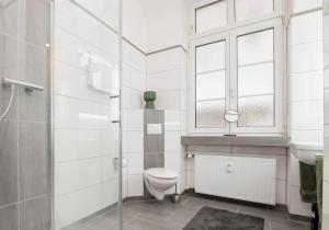 La salle de bains est pourvue de toilettes et d'une fenêtre. dans l'établissement Center Elegance Light Apartment, à Krefeld