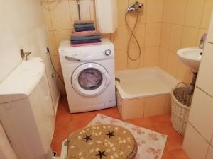 uma pequena casa de banho com uma máquina de lavar roupa e um lavatório em Air Zagrebart Studio Apartment em Zagreb