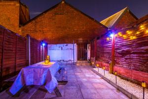 un patio con una mesa y luces en un edificio en Stylish 3Bed Retreat - Walk to Coventry's Delights en Coventry
