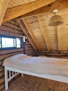 1 dormitorio en una cabaña de madera con 1 cama en Estadia de campo en San Andrés de Giles