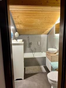 a bathroom with a tub and a sink and a toilet at Appartements Mair in Strobl in Strobl