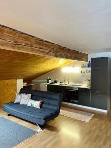 sala de estar con sofá azul y cocina en Appartements Mair in Strobl en Strobl
