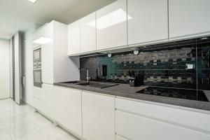 uma cozinha com armários brancos e um lavatório em Famille, Parking, Balnéo - 15min Centre em Estrasburgo