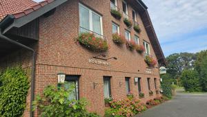 ein Backsteingebäude mit Blumenkästen an der Seite in der Unterkunft Gästehaus Grunewald Bed & Breakfast in Heiden