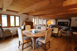 a dining room with a wooden table and chairs at Appartement Herbelands Est in Rougemont