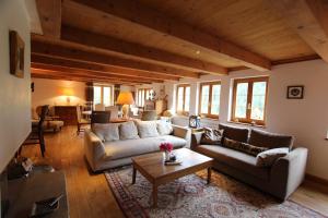 a living room with two couches and a table at Appartement Herbelands Est in Rougemont