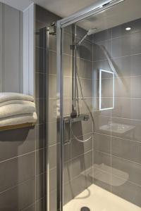 een douche met een glazen deur in de badkamer bij Ring of Bells in North Bovey