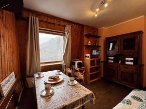 a living room with a table and a window at House Betulle by Holiday World in Sella della Turra