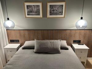 um quarto com duas mesas de cabeceira e uma cama com dois candeeiros em Apartamentos Universidad em Múrcia