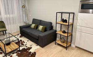 uma sala de estar com um sofá e uma cozinha em Apartamentos Universidad em Múrcia
