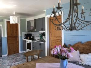a kitchen with a table with a vase of flowers at Påboda, Smaland, South Sweden in Söderåkra