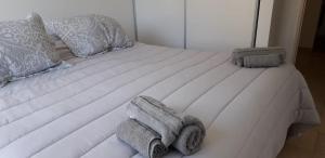 a white bed with towels and pillows on it at Espacio Aristobulo in Comodoro Rivadavia