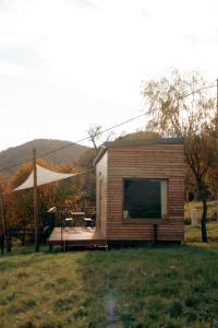 a small cabin in a field with a large window at kiva cabin in Horné Hámre