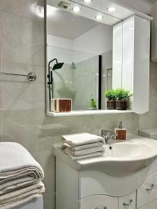bagno bianco con lavandino e specchio di Parc Vatra Dornei 2 - Family, couples & groups a Vatra Dornei