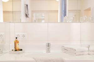 a white bathroom with a sink and a mirror at Brauereigasthof Krone in Tettnang