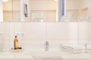 a white bathroom with a sink and a mirror at Brauereigasthof Krone in Tettnang +28 photos