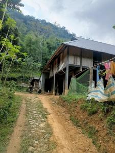 ein Haus auf einer unbefestigten Straße neben einer unbefestigten Straße in der Unterkunft Puluonghomestay2 in Làng Cào