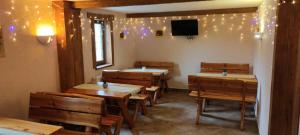 a restaurant with tables and chairs and a tv on the wall at Chata Zieleniecka in Duszniki Zdrój