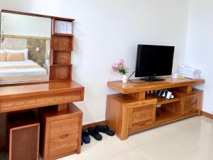 a bedroom with a bed and a television on a desk at ZoZo House - Homestay Bai Sau 77 in Vung Tau