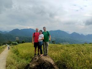 a family standing on top of a rock in a field at Puluonghomestay2 in Làng Cào