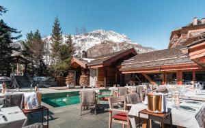 a restaurant with tables and chairs next to a pool at Hôtel LE BLIZZARD in Val-d'Isère