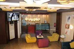 una sala de espera con sillas coloridas y TV en Yanbu Inn Residential Suites, en Yanbu