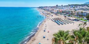 an aerial view of a beach with umbrellas and the ocean at Apartamento La Carihuela in Torremolinos