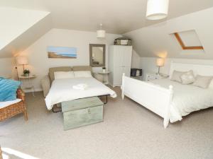 a bedroom with two beds and a couch at Burwyns in Ventnor