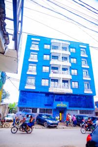 motorrijders voor een blauw gebouw bij RESIDENCE BELMANN in Douala